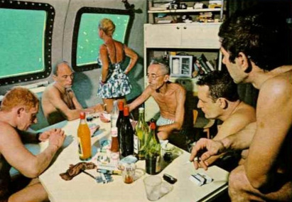 Jacques Cousteau at table with crew drinking wine 
and smoking as his wife Simone gazes out the window, 
10 meters beneath the Red Sea