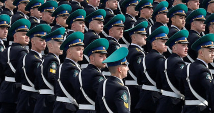 Officers with teal caps in formation, marching