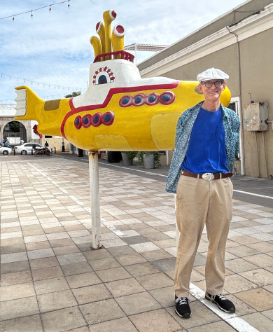 Old guy standing in front of a Yellow Submarine statue in Mexico