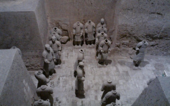 view looking down into excavated pit of terra cotta warriors, many of them headless